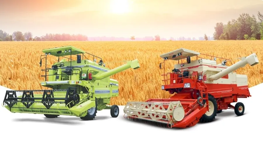 Two modern combine harvesters in front of a golden wheat field at sunset